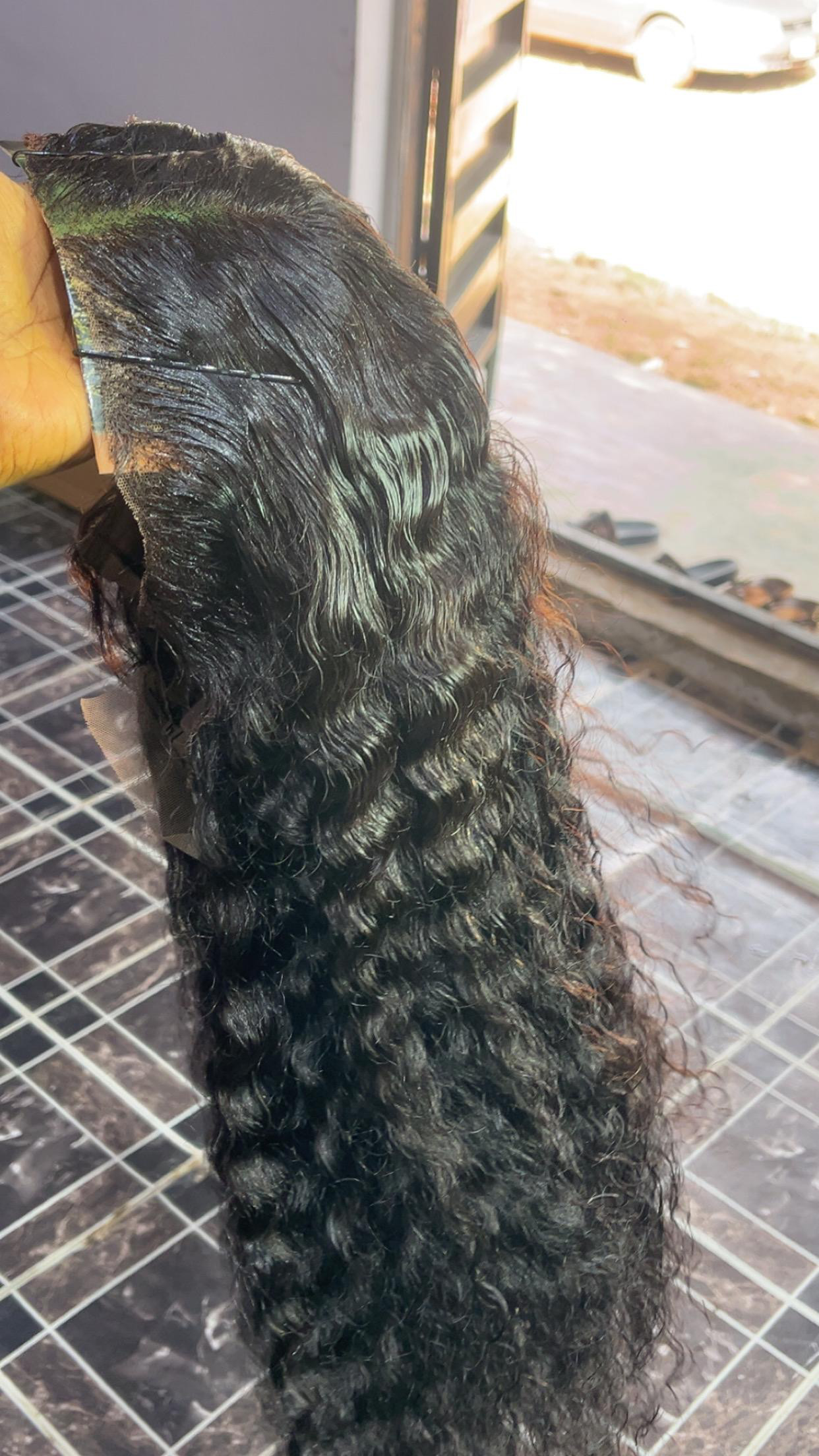 Long deep-curly frontal wig held up to show density and curl pattern